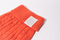 A close up on a Burnt orange cable knit dog jumper with Bew Dogs label and ribbed neckline for small dogs 
