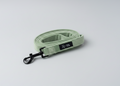 A sage green velvet dog lead, soft strong and durable, with black clasp sits on a grey background 