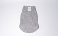 A light gray knit dog jumper with a cable-knit pattern and a white Bew Dogs brand label on the collar, shown against a plain light gray background - perfect for puppies and small dogs 