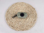 Sundown Collection dog poo bag holder in sage green, sits on a woven mat against a grey background