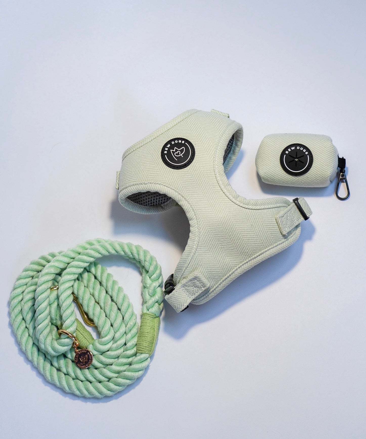 a gorgeous and curated walking set with mint green herringbone harness, matching poo bag holder for convenience and a stunning green rope lead, against  white background