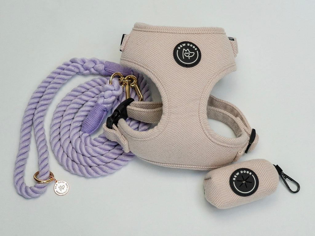 Dog harness, lead, and poo bag holder with brand logo on a light grey background - the ultimate lilac walking set