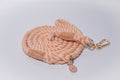 Beige rope dog leash with gold clip and tag on a light grey background. soft but durable, for everyday walks. 