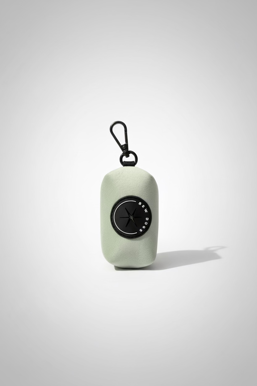 a lush sage green velvet dog poo bag holder with clip, in a studio shot against a grey background
