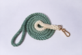 A gorgeous deep Sage two-tone, ombre rope lead For dogs, in white and green - coiled with gold Hardware against a grey studio background. This dog lead is both soft and strong and suitable dog large dogs and dogs of all sizes 