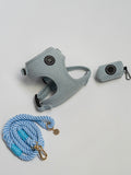 a herringbone blue dog walking set, including blue harness, matching poo bag holder and soft rope lead sits on a white background, showcasing everything needed for comfortable, stylish walks