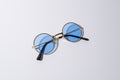 round blue lens sunglasses for dogs, with gold hardware sit against a white background