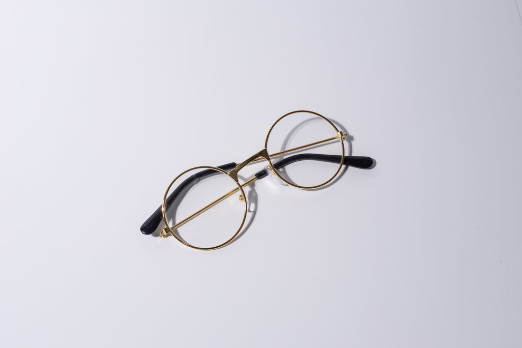Round eyeglasses with gold frame, fun novelty item for cats and dogs, on a white background