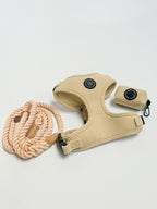 a cream dog harness walking set including soft herringbone harness, matching poo bag holder that clips on to the stylish cream rope lead. set against a soft grey studio background