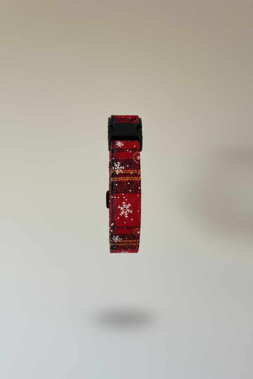 a festive red christmas collar in plaid material for dogs, shown against a grey backdrop