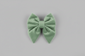a soft, adjustable sage green velvet sailor bow for dogs, set against a grey background