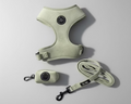 a sage green velvet dog harness,with matching walking accessories: a lead and poo bag holder, against a grey background