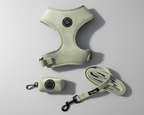 a sage green velvet dog harness,with matching walking accessories: a lead and poo bag holder, against a grey background