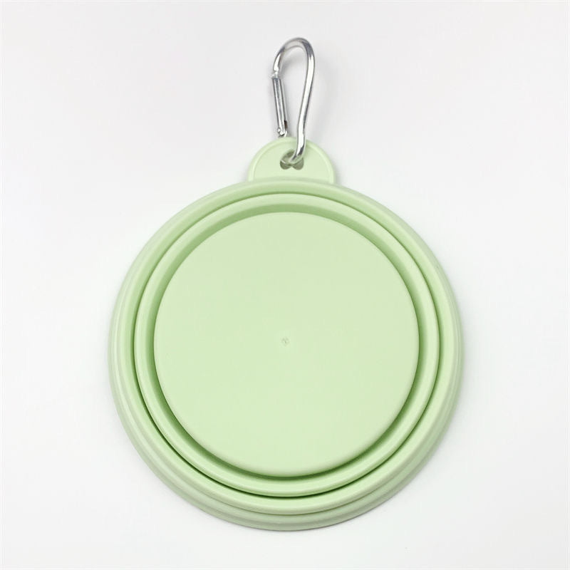 Light pastel green silicone dog bowl with a carabiner on a white background