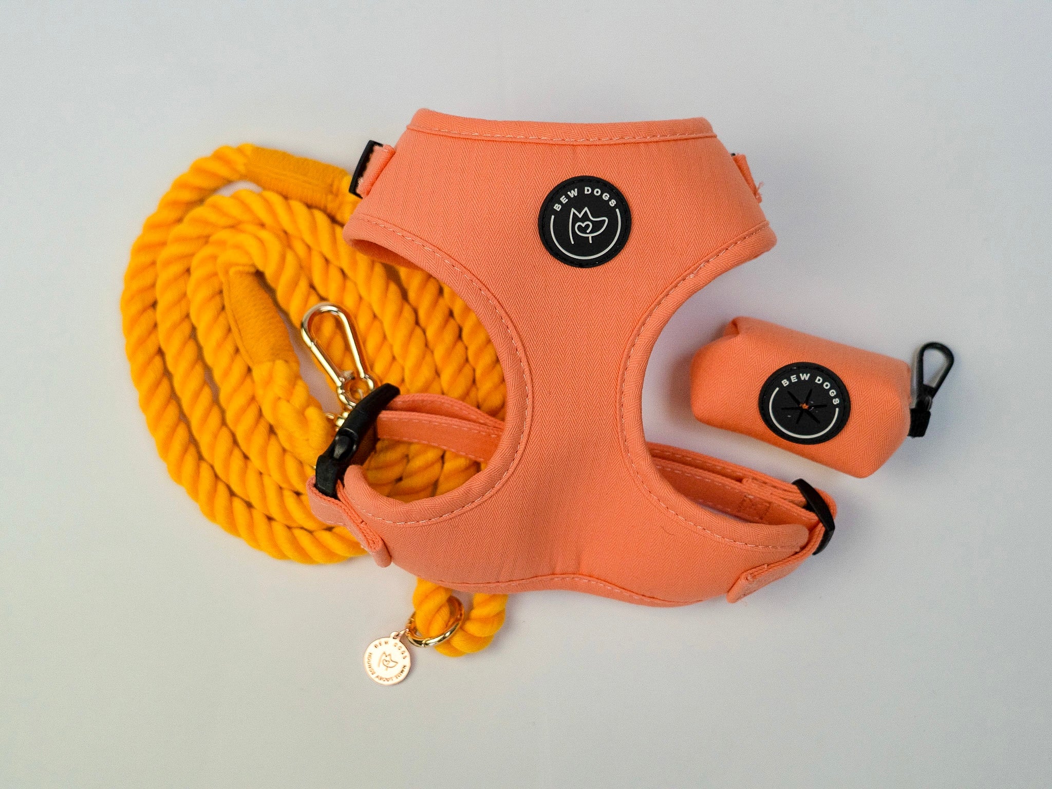 a curated walking set showing peach orange dog harness, honey orange rope lead and a matching poo bag holder, discounted and providing everything needed for a comfortable dog walk. shown against a white background
