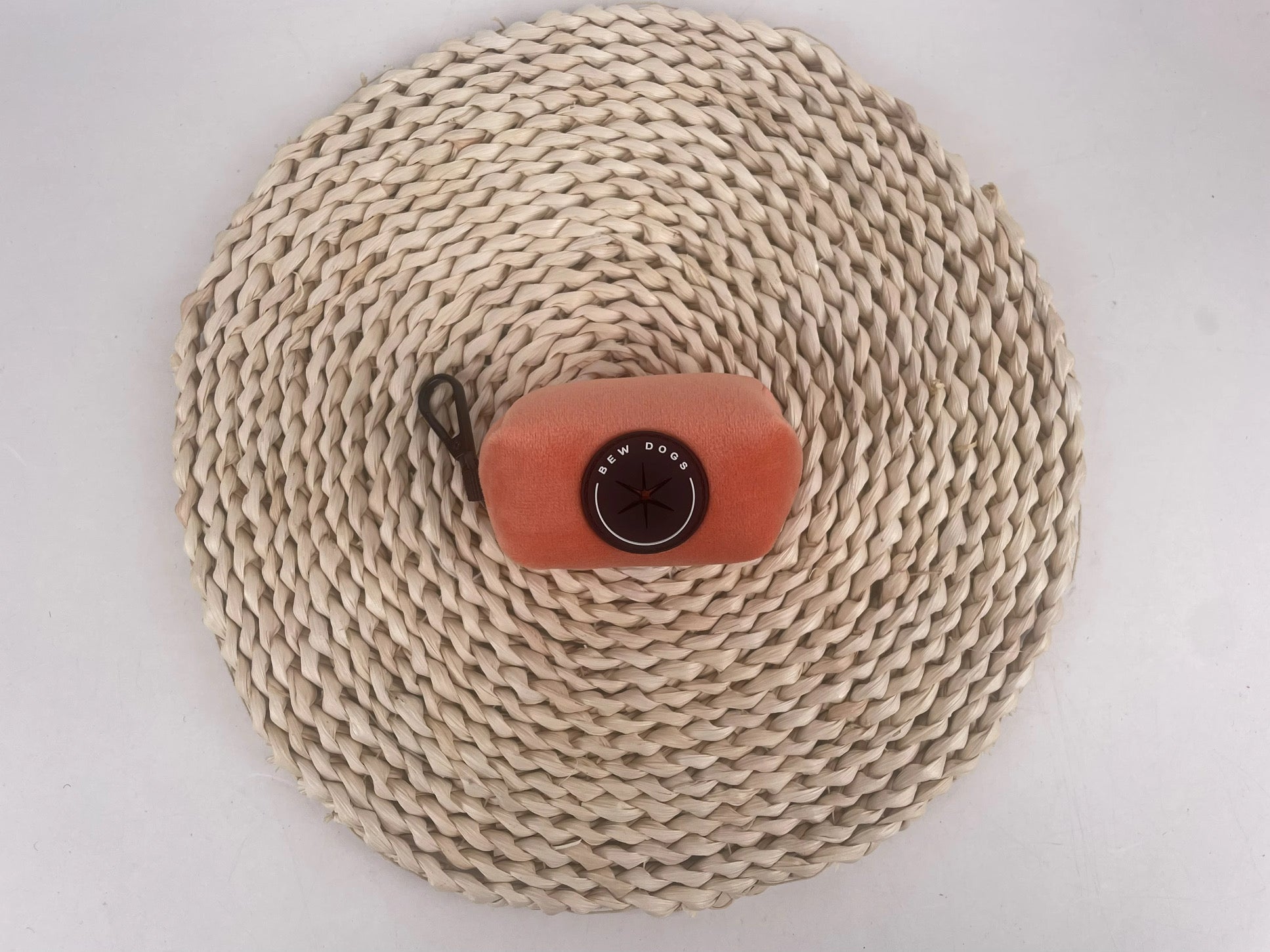 Sundown Collection dog poo bag holder, a must have dog walking accessory, is shown on a rope mat, against a grey background