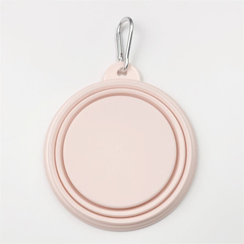 A light pink collapsible pet water bowl with a silver metal carabiner clip at the top, shown on a clean white background.