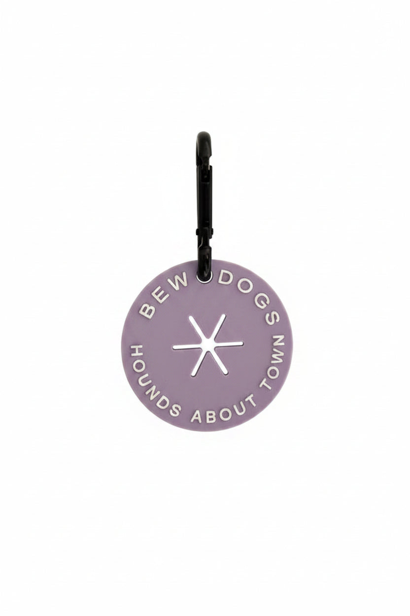 A lilac poop loop from Bew Dogs, used to secure dirty dog waste bags on walks and keep you hands free! shown against a white background in a studio.