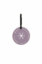 A lilac poop loop from Bew Dogs, used to secure dirty dog waste bags on walks and keep you hands free! shown against a white background in a studio.