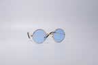 Round sunglasses with gold frame, novelty and fun item for cats or dogs, with blue lenses, sit against a light gray background