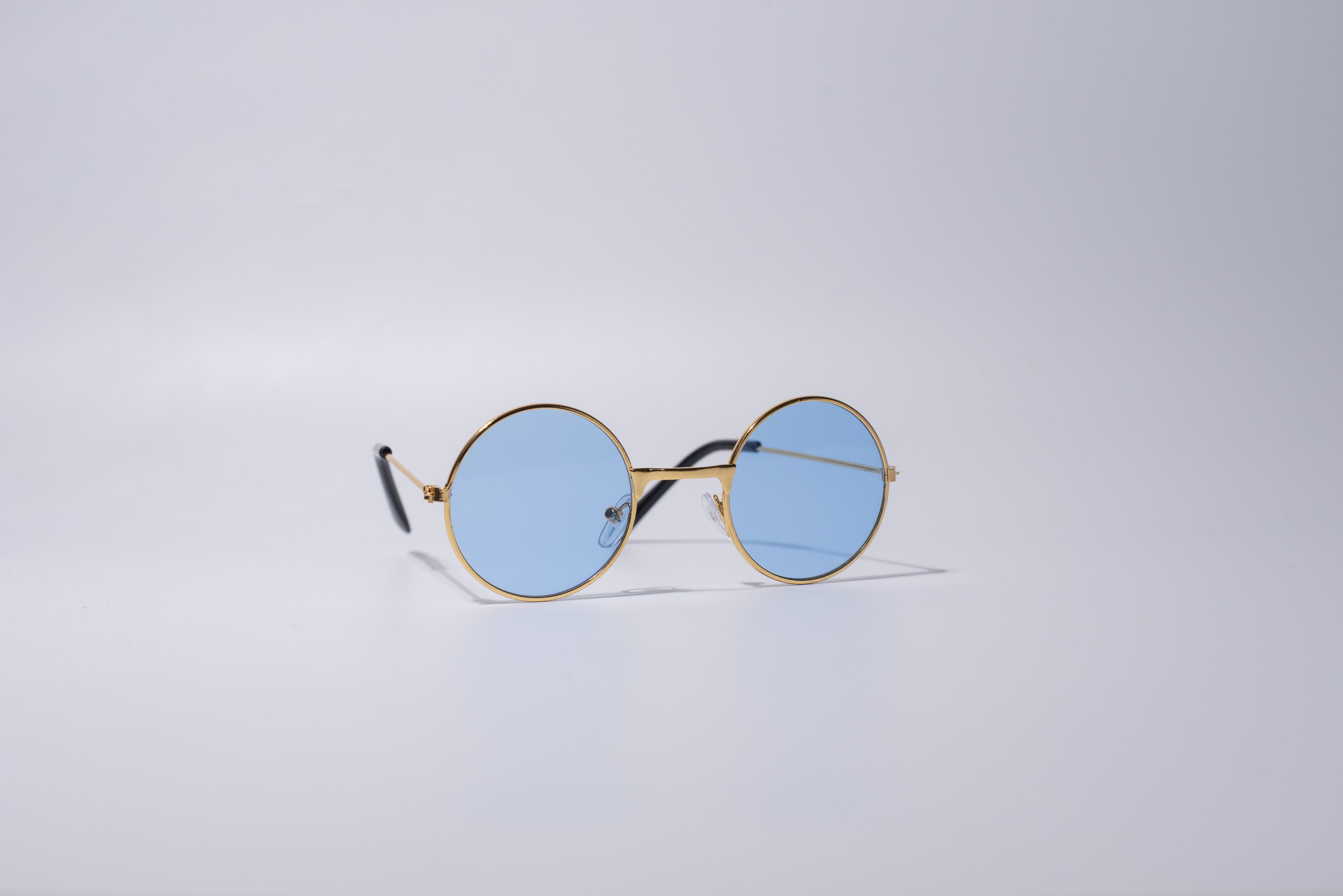 Round sunglasses with gold frame, novelty and fun item for cats or dogs, with blue lenses, sit against a light gray background