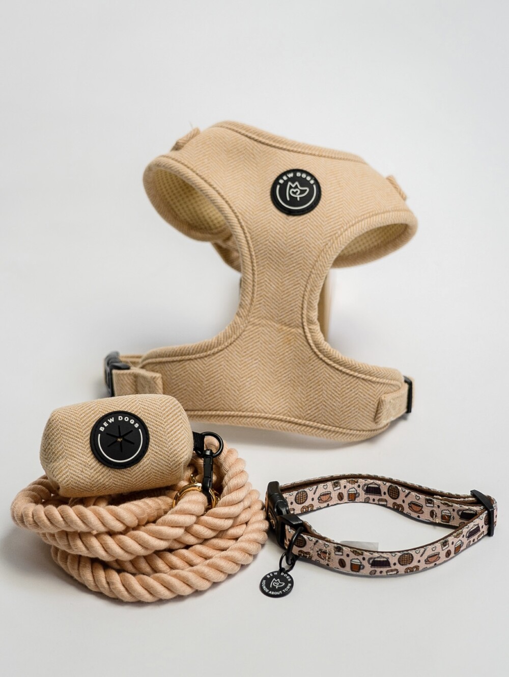 A cream herringbone harness, matching poop bag holder and rope lead plus a cream collar, against a white background.