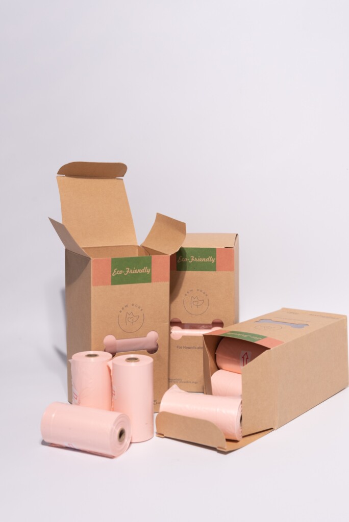 A stack of three boxes of eco-friendly and sustainable, biodegradable poo bags. each box contains 8 rolls of strong, stylish peach coloured poo bags. 