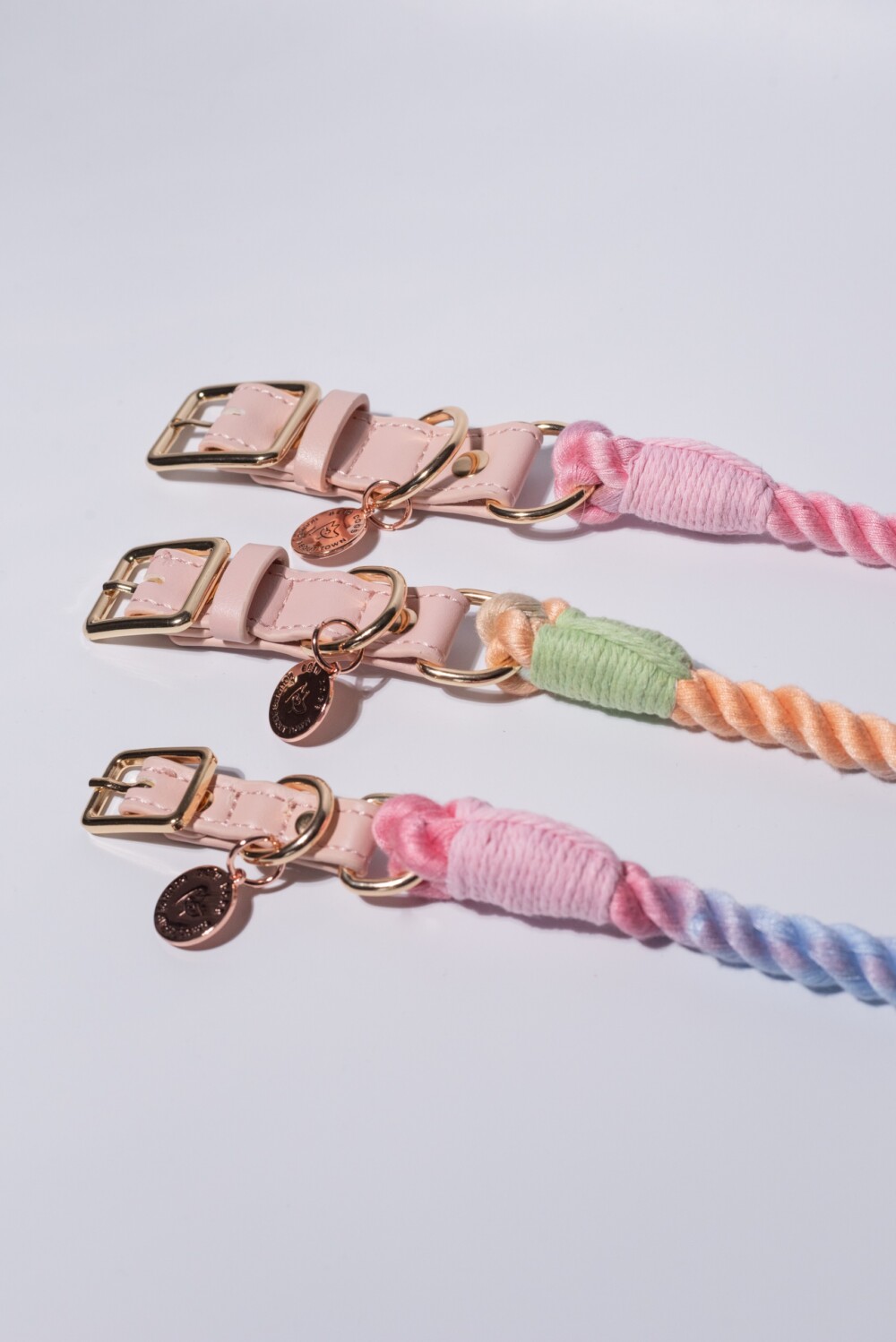 Three rainbow rope collars in different pastel shades, against a white background