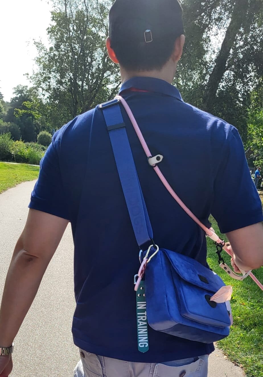 man-walking-dog-with-dog-walking-bag-over-shoulder